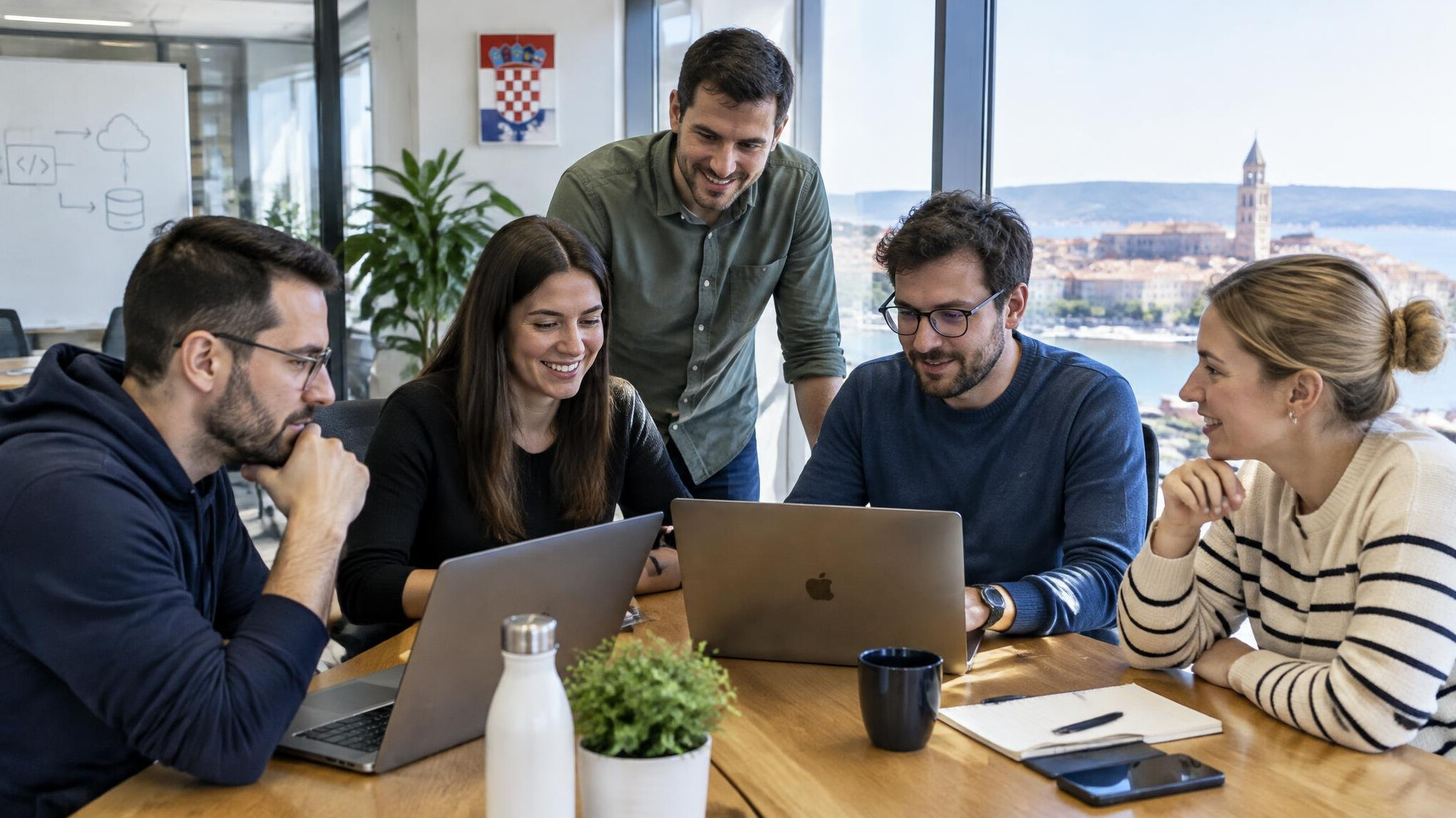 Team of software developers collaborating around a table in a modern office